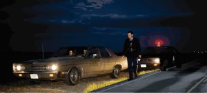 A constable approaches a vehicle with a male driver and female passenger late at night.